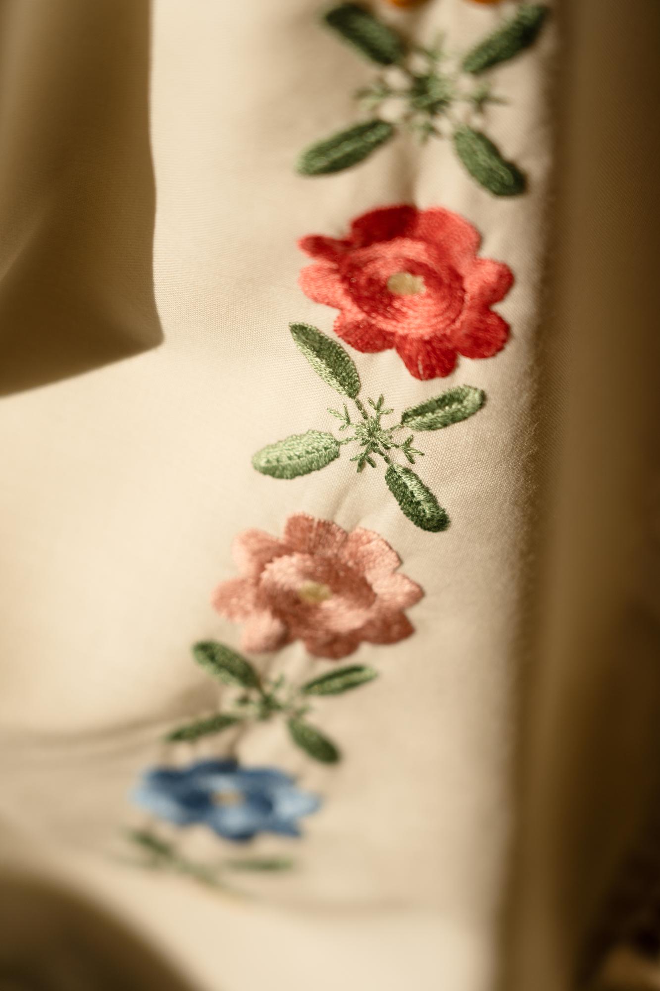 Artisan stitching floral motif on natural linen